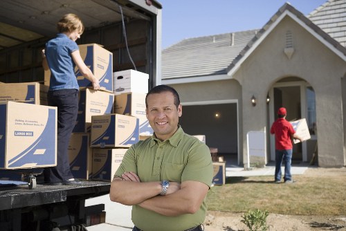 Professional movers handling desks and cabinets during an office move