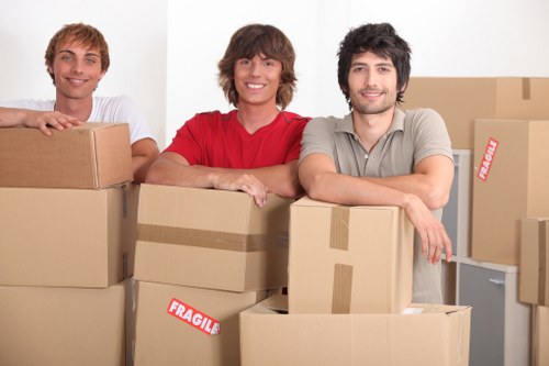 Local movers carrying furniture down stairs in a Harrow property