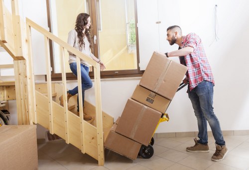 Removal crew carrying items through a Harrow property